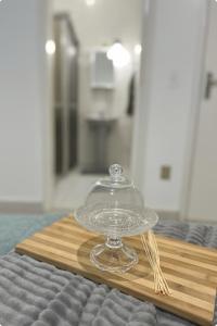 Acolhedora casa de 03 quartos في باسوس: خزانة كعك زجاجية موضوعة على صينية خشبية على طاولة