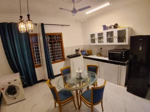 a small kitchen with a glass table and chairs at Malaika White House Apartment & Spa in Kiwengwa