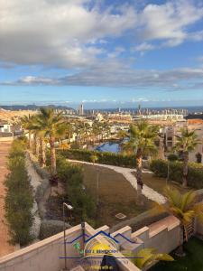 een uitzicht op een stad met palmbomen en gebouwen bij Sunrise at Finestrat in Finestrat