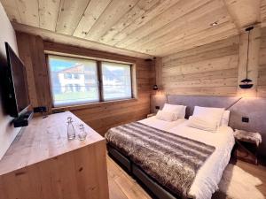 een slaapkamer met een bed in een houten hut bij Hameau des clos Téléporté in Les Gets