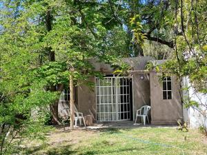 a small house with two chairs in the yard at Las Glicinas de Chacras in Chacras de Coria