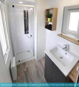 Un baño blanco con lavabo y ducha. en Siblu Camping in de Bongerd, en Oostkapelle