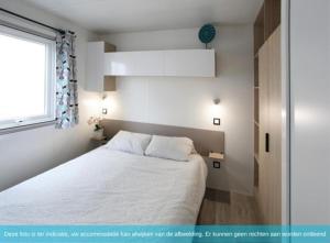 Un dormitorio con una cama blanca y una ventana. en Siblu Camping in de Bongerd, en Oostkapelle 26 fotos más