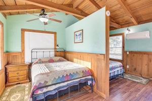 Peaceful Mountain Cabin with Views in Williamsburg في ويليامزبرغ: غرفة نوم بها سرير ومروحة سقف