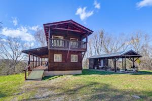 Peaceful Mountain Cabin with Views in Williamsburg في ويليامزبرغ: منزل على تلة مع شرفة