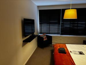 a bedroom with a bed and a chair and a lamp at Guest room with private bathroom, WiFi, TV, Antwerp in Antwerp