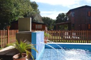 a pool with a water fountain in a yard at Gosén Cabañas Sanagasta in Villa Bustos