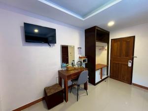 a room with a desk and a television on the wall at Sabai House in Phi Phi Don