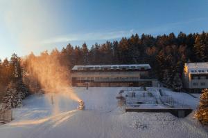 a person skiing in the snow in front of a building at Hotel Monínec in Moninec
