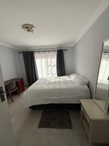 a bedroom with a bed and a window at Da Silva Apartment in George