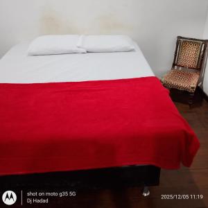 een bed met een rode deken en een stoel bij Santa Alexandrina in Rio de Janeiro