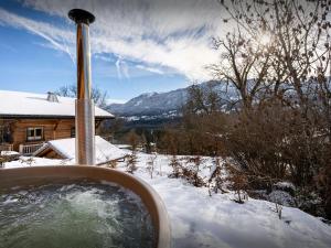 een hot tub in de sneeuw voor een huis bij Chalet Lezopau - OVO Network in Samoëns