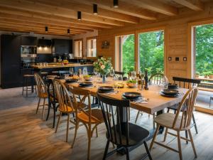 een eetkamer met een grote houten tafel en stoelen bij Chalet Lezopau - OVO Network in Samoëns