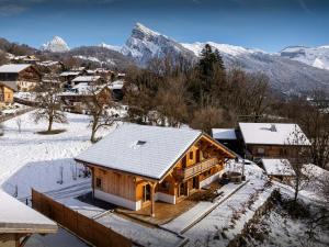 een huis in de sneeuw met bergen op de achtergrond bij Chalet Lezopau - OVO Network in Samoëns