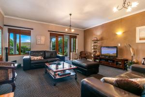 un soggiorno con un divano e una TV di Waterfront Lodge a Knysna