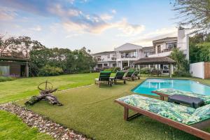 un cortile con piscina e una casa di Waterfront Lodge a Knysna