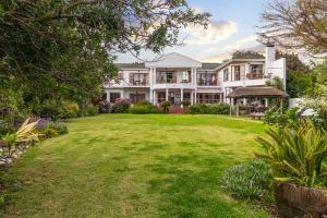 una grande casa bianca con un ampio cortile di Waterfront Lodge a Knysna