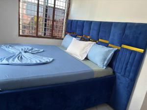 a blue bed with blue sheets and pillows on it at Malaika White House Apartment & Spa in Kiwengwa