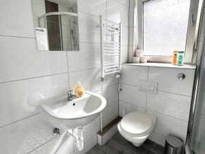 a white bathroom with a sink and a toilet at Gemütliche Apartments in Herten in Herten