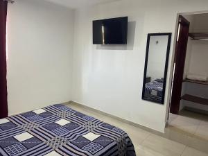 a bedroom with a bed and a tv on the wall at Hotel Sierra Bonita in Huasca de Ocampo