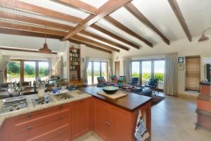 een keuken met houten plafonds en een woonkamer bij Blombossie in Arniston +35 foto's