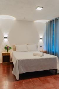a bedroom with a white bed with blue curtains at Gaestehaus ESSENCE 