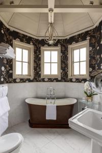 a bathroom with a tub and a toilet and a sink at The Goring in London