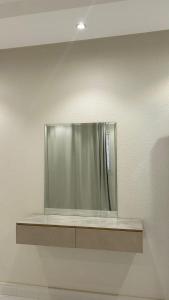 ein silberner Kühlschrank an einer Wand mit einem Regal in der Unterkunft شقق فخامة العاصمة in Riad