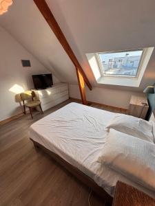 ein Schlafzimmer mit einem Bett und einem Dachfenster in der Unterkunft Ti Laja - nuage de coton 30m plage in La Baule-les-Pins + 4 Fotos