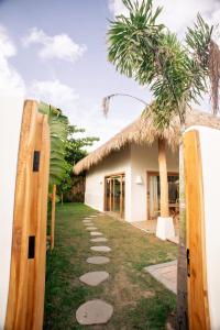 a house with a palm tree and a pathway at Irama Surf Villas - Private Pool Villas at Yoyos in Sekongkang