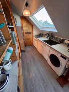 eine kleine Küche mit Spüle und Fenster in der Unterkunft Ti Laja - nuage de coton 30m plage in La Baule-les-Pins