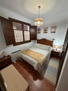 una camera da letto con un letto e un lampadario di Casa Rural Grazalema a Grazalema