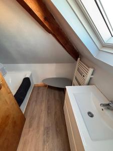 ein Badezimmer mit Waschbecken und Tisch auf einem Dachboden in der Unterkunft Ti Laja - nuage de coton 30m plage in La Baule-les-Pins