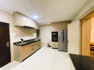 een keuken met roestvrijstalen apparatuur en witte tegelvloeren bij Mikuch Apartments and Suites in Abuja