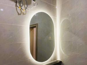 een badkamer met een ronde spiegel aan de muur bij Mikuch Apartments and Suites in Abuja +51 foto's
