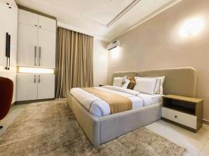 een slaapkamer met een groot bed in een kamer bij Mikuch Apartments and Suites in Abuja