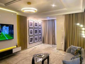 een woonkamer met een bank en een tv bij Mikuch Apartments and Suites in Abuja