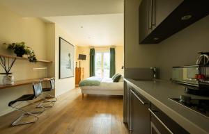 a kitchen with a sink and a bed in a room at La Villa Fleury - La Nacre in Limoges