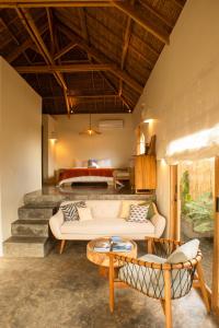 una sala de estar con un sofá y una cama en Irama Surf Villas, en Sekongkang Bawa