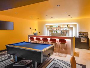 a bar with a pool table and a bar with stools at ibis Styles Avignon Sud in Avignon