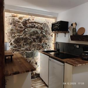 a kitchen with a stone wall and a counter top at Ferien im Kayserreich in Reichelsheim +17 photos