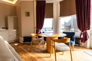 a living room with a table and chairs and a window at Antrim House Guest Rooms & Suites in Portrush