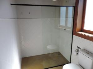 a glass shower in a bathroom with a toilet at Pousada Melhor Hora in Cunha