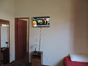 a television hanging on a wall in a bedroom at Pousada Melhor Hora in Cunha +15 photos