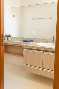 a bathroom with a sink and a mirror at Vista para as Montanhas in Guarapari