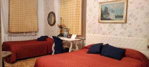 a hotel room with two beds and a table with at b&b Casa Galletti in Busalla