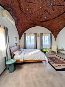 a bedroom with a large bed with a brick ceiling at The Roof by Barefoot in Tunis in Tunis