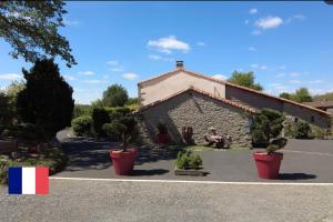 a building with potted plants in front of it at Au Petit Bignon in Les Épesses