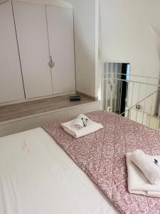 una camera da letto con letto, specchio e asciugamani di Casetta Piazza Plebiscito a Napoli Altre 119 foto