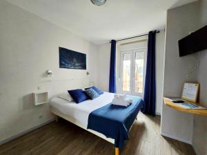una camera da letto con un letto con lenzuola blu e una finestra di LAYTON - A 2 min de la plage, du sillon et d'Intra muros ! a Saint Malo
